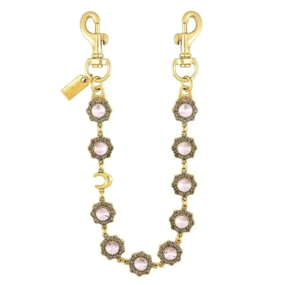 Gold-toned crystal petal keychain with rhinestone charm hanging from a split ring.