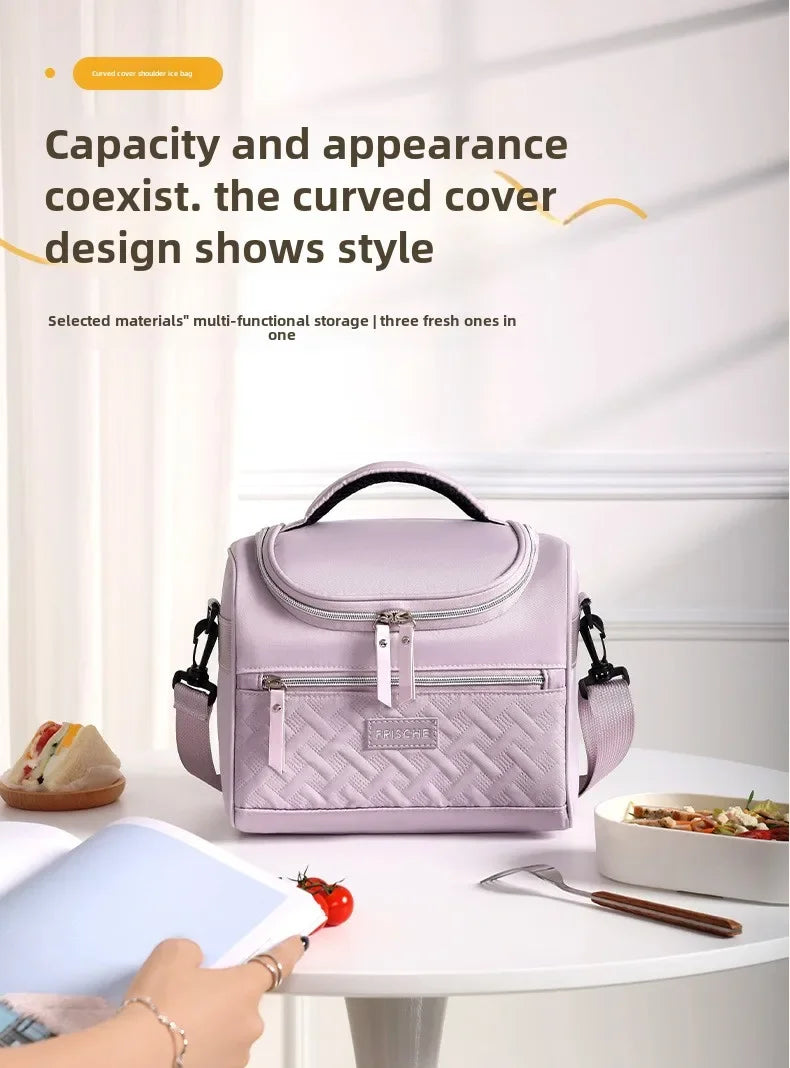 Una bolsa térmica de color lila claro con diseño acolchado, mostrada sobre una mesa blanca.