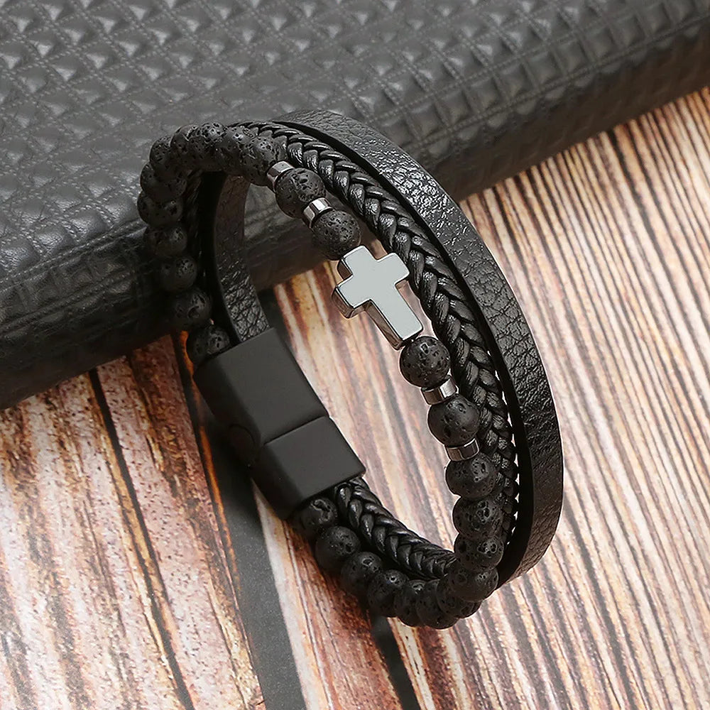 A black leather bracelet featuring multiple layers of beads and a silver cross charm.