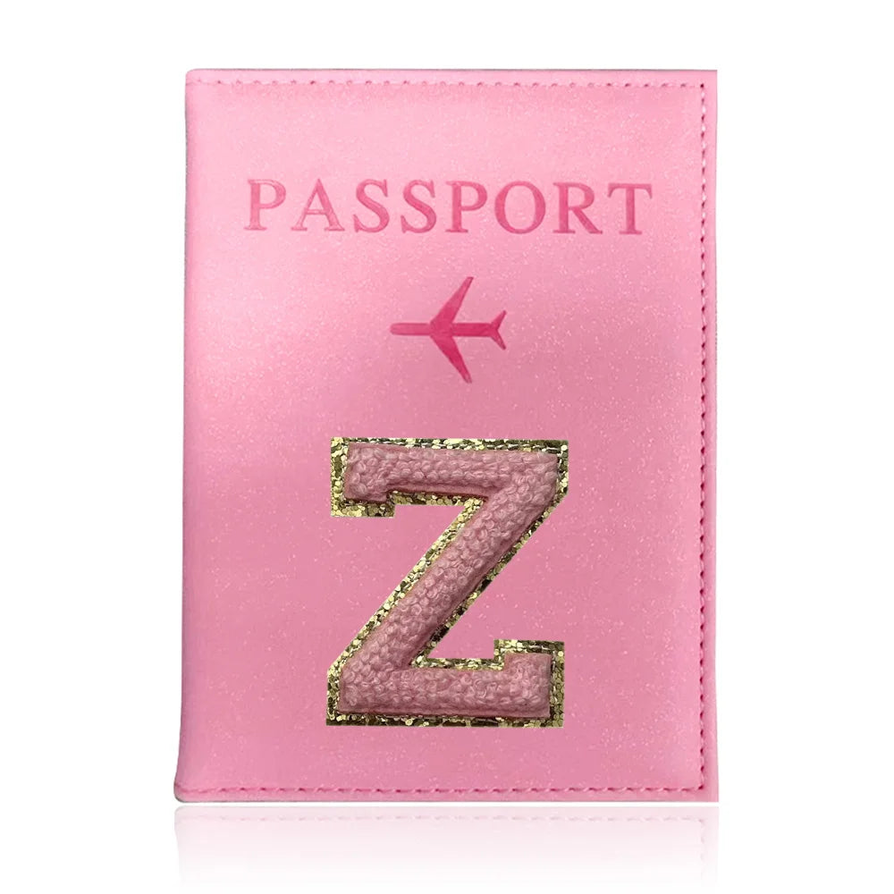A pink leather passport holder with a gold initial Z and a pink airplane design.