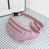 A pink multi-layer sports waist bag with a zipper and strap is displayed on a checkered surface.