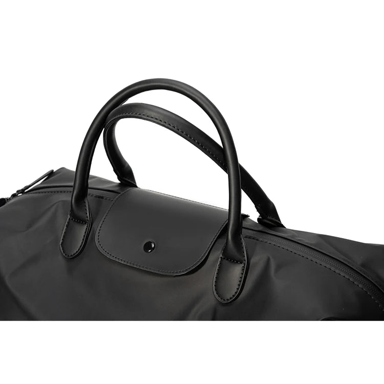 A black durable nylon travel duffle bag with leather handles shown from the side.
