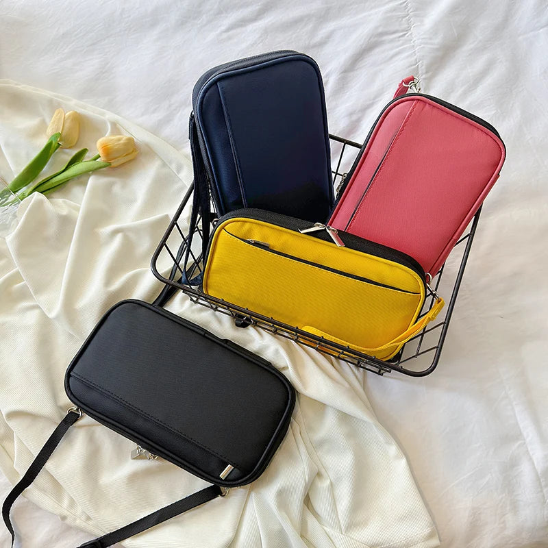 A black and pink travel document organizer with multiple pockets is displayed on a white sheet.