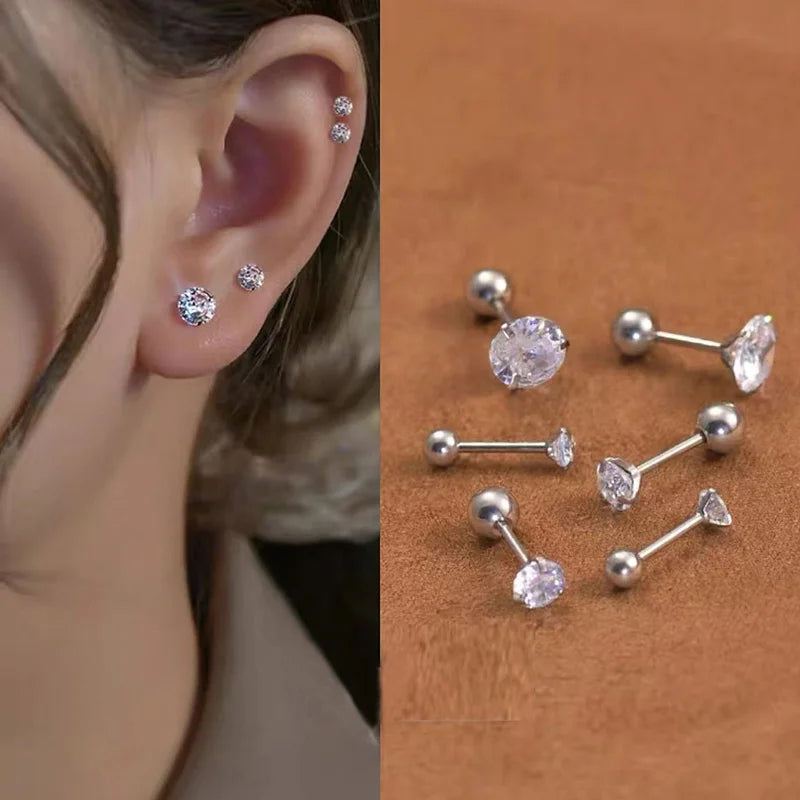 A set of silver-toned stainless steel ear stud earrings featuring round and teardrop-shaped clear stones.