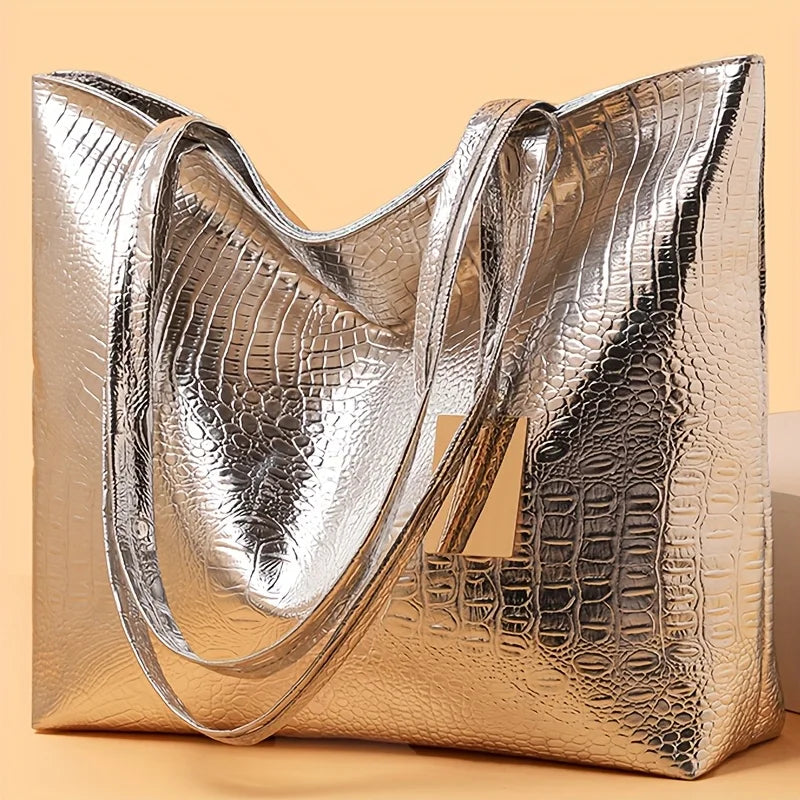 A close-up of an elegant metallic gold crocodile print zipper tote bag.