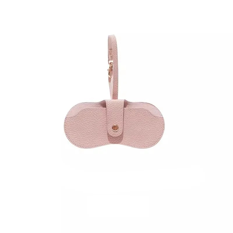 Estuche de gafas de cuero delgado rosa con correa y cierre de presión.