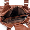 Braune Vintage Soft PU Leder-Schultertasche, geöffnet, mit Innenfutter und Reißverschlussdetails.