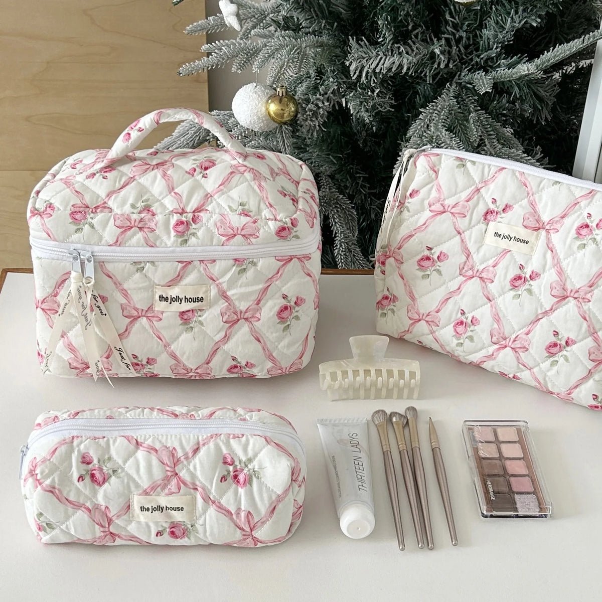 A collection of floral embroidered makeup bags and brushes displayed on a white surface.
