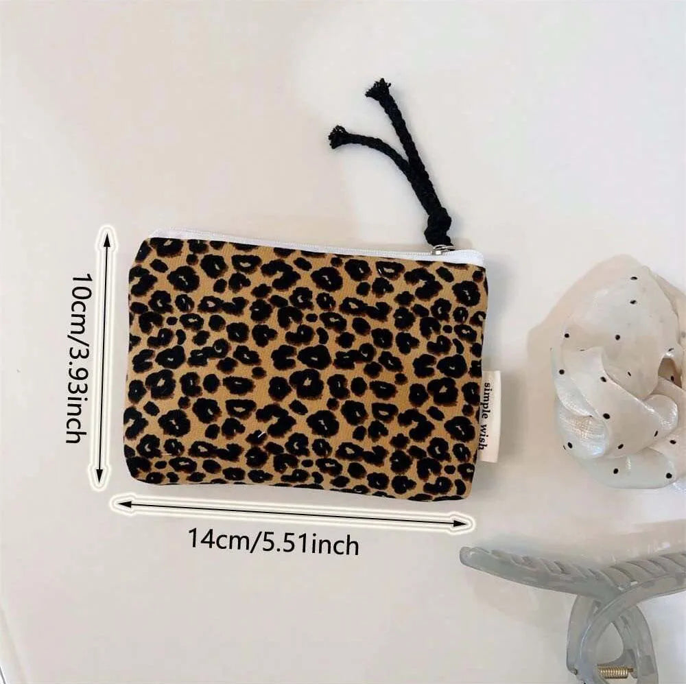 A leopard print cosmetic bag is shown next to a measuring tape, demonstrating its size.