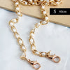 Gold-toned adjustable chain strap featuring small white pearls, shown against a neutral background.