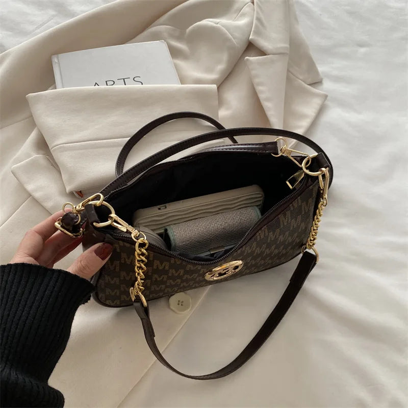 Bolso cruz de cuero dorado vintage marrón oscuro sobre tela blanca.