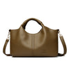 A brown leather tote bag with a handle and shoulder strap is shown against a white background.
