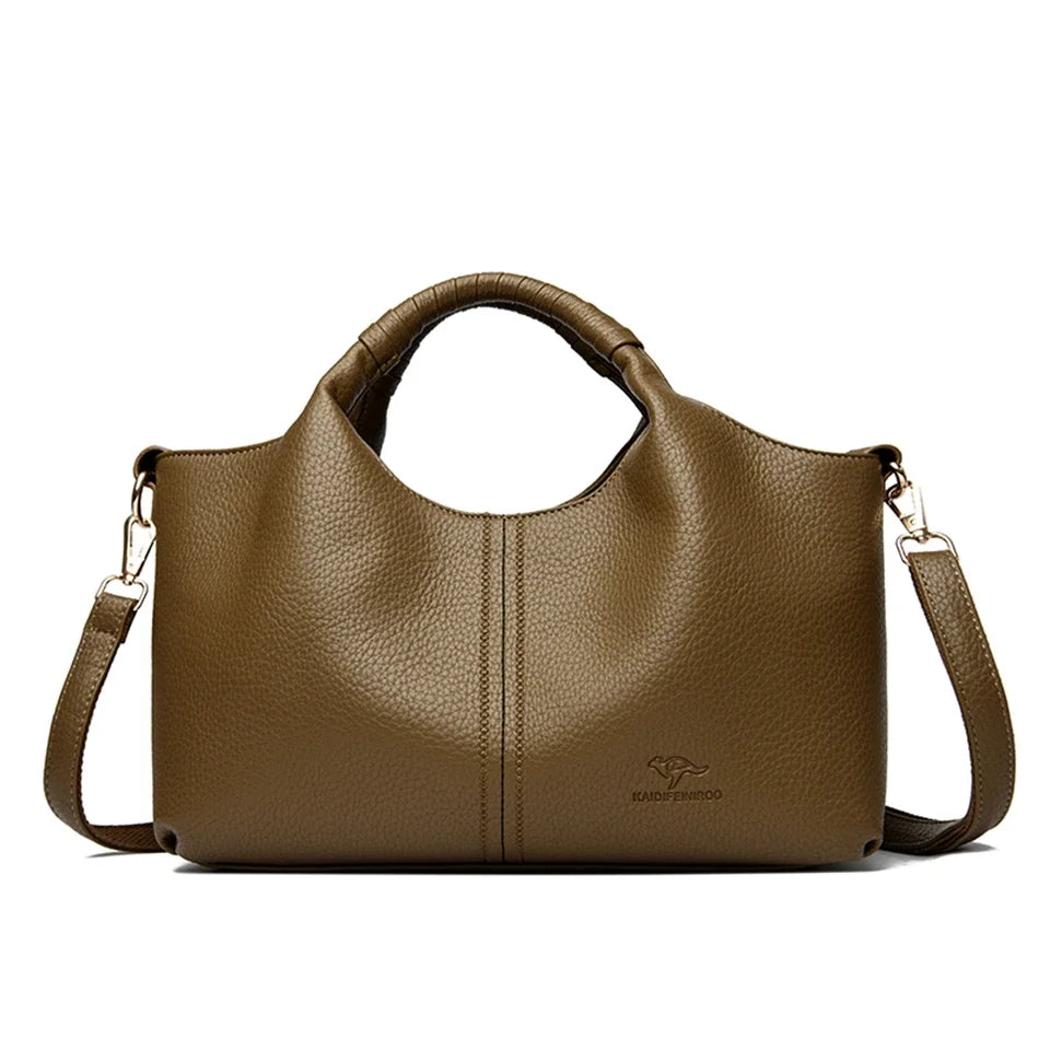 A brown leather tote bag with a handle and shoulder strap is shown against a white background.