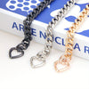 Three heart-shaped metal purse chains in black, silver, and gold displayed on a white background.