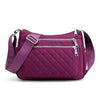 A purple quilted nylon crossbody tote bag with a silver zipper and strap.