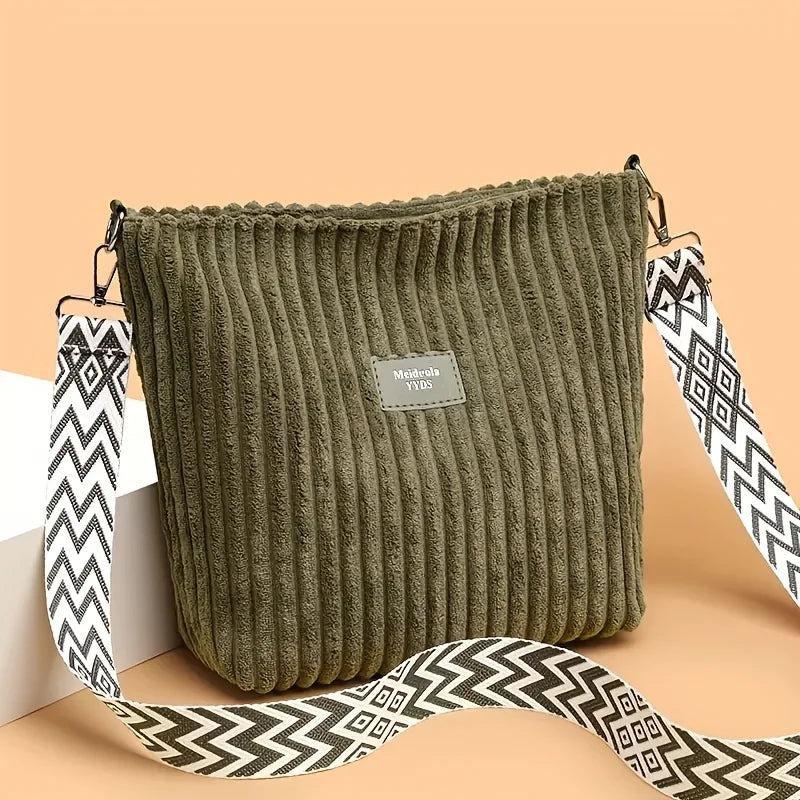 Sac à épaule et bandoulière en velours côtelé vert olive foncé avec une sangle à motif noir et blanc.