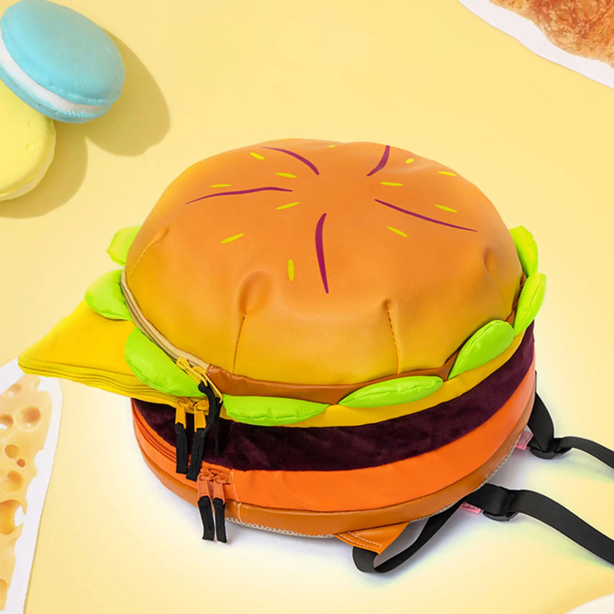 A novelty backpack shaped like a cheeseburger, featuring an orange bun and toppings.