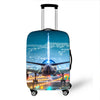 A silver suitcase with a blue cityscape and waterfall design is shown on wheels.