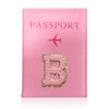 A pink leather passport holder with a gold embossed letter B and a pink airplane symbol.