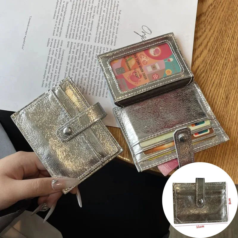 A close-up of a genuine leather compact coin purse and key holder in silver and gold tones.