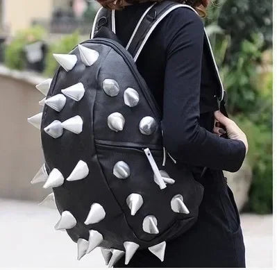 A black unisex backpack featuring a riveted pattern design worn by a person.