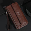 Portefeuille pochette à fermeture éclair en cuir marron pour homme sur une surface sombre.