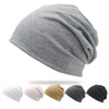 A collection of slouchy knit beanie hats in white, pink, tan, gray, and black.