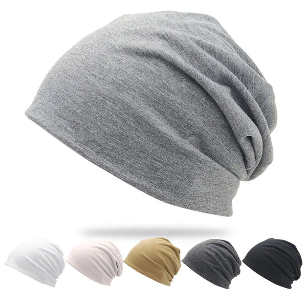 A collection of slouchy knit beanie hats in white, pink, tan, gray, and black.