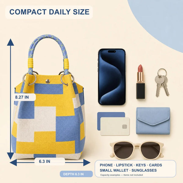 Bolso de mimbre geométrico amarillo y azul junto a un smartphone, labial, llaves, tarjetas y gafas de sol.