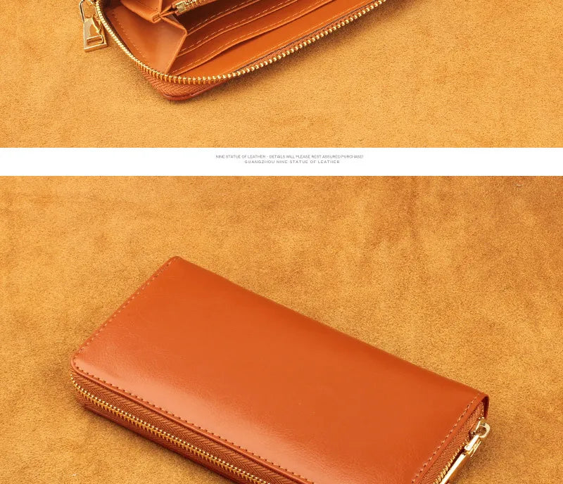 A close-up of a tan leather zipper wallet resting on a textured brown surface.