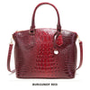 Bordeauxrotes Krokodilmuster-Top mit Henkel und Crossbody-Tasche.