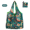 A reusable fashion shopping tote bag featuring a floral pattern in shades of green and pink.