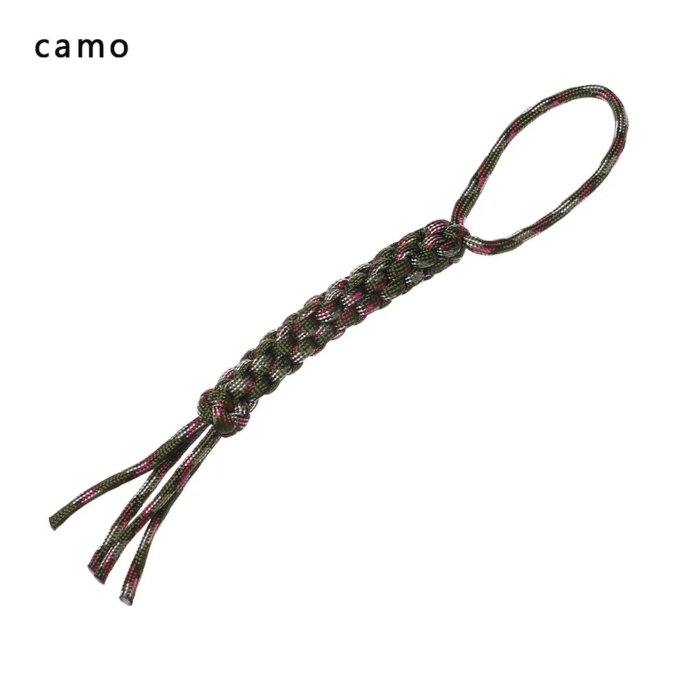 A close-up of a dark green and pink 7-strand paracord keychain with a loop and dangling strands.