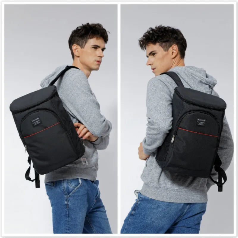 A man is shown wearing a black insulated thermal cooler backpack while standing against a light gray background.