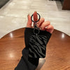 Une main tient une coque de protection à motif zèbre noir pour AirPods Pro.