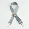 A gray nylon adjustable shoulder strap with a gold buckle and metal clasps.