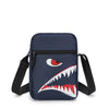 Pochette de téléphone crossbody bleu marine avec motif dent de requin stylisé et sangle noire réglable.