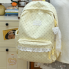 A cream-colored polka dot nylon travel backpack with a laptop compartment and lace trim.