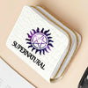 A white quilted wallet with gold stitching and a purple sun symbol on the cover.