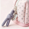 A pink pencil case with a zipper and a gray fabric tie attached, featuring a subtle dot pattern.