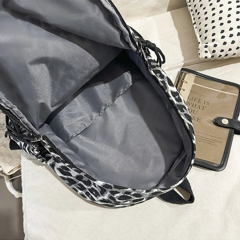 Gray leopard print canvas backpack open showing the interior lining and black straps