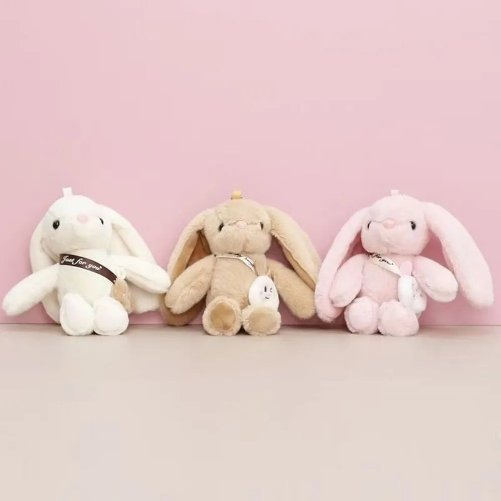 Three plush rabbit toys in white, beige, and pink colors displayed against a light background.