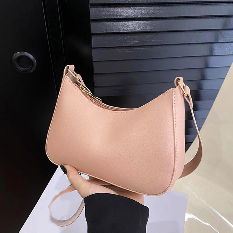 A light pink retro solid color PU leather shoulder bag with a tan strap shown against a dark background.