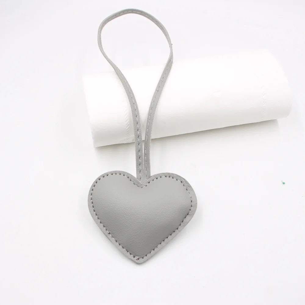 A small gray PU leather heart shaped keychain attached to a loop.