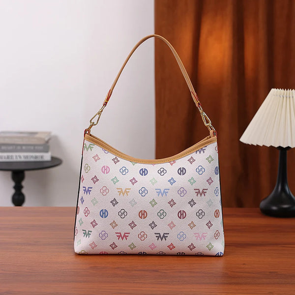 A beige canvas tote bag with a repeating letter print and bow accent resting on a wooden table.