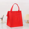 A bright red insulated tote bag with a handle is displayed on a white marble surface.