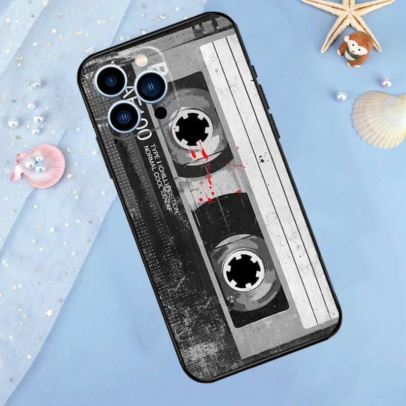 A black phone case with a vintage cassette tape design featuring multiple circular cutouts and distressed texture.