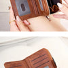 A close-up of a brown leather multi-function wallet with a zipper closure and RFID blocking features being held by a hand.