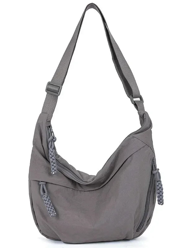 A gray soft nylon crossbody shoulder bag with an adjustable strap.
