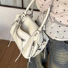 A white retro motorcycle PU leather crossbody shoulder bag is shown being held by a person.